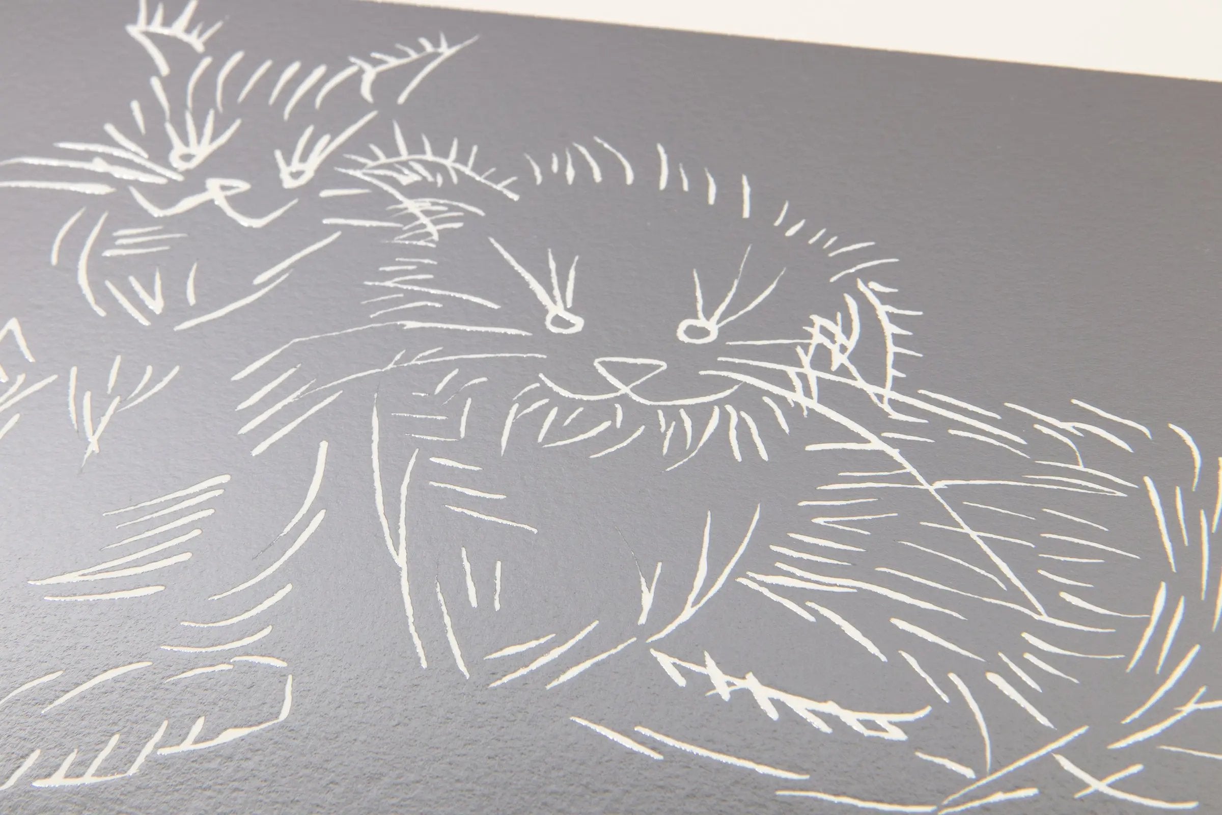 Detail of Ai Weiwei Cats Silver foil artwork highlighting engraved cat figures and reflective texture
